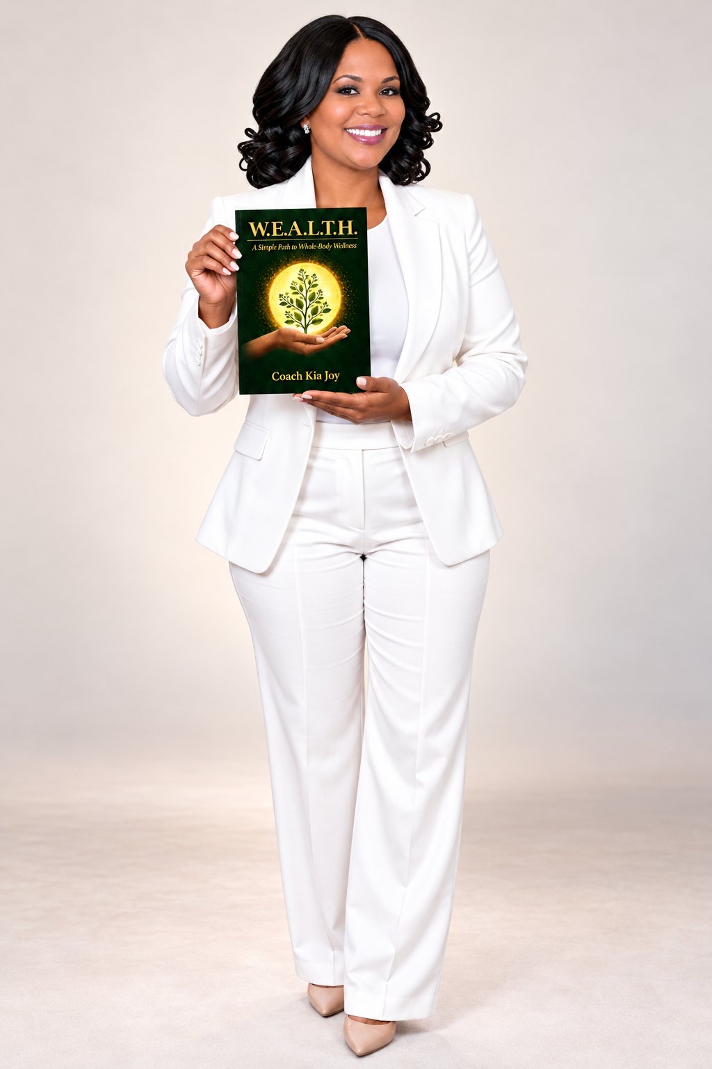 Coach Kia Joy holding her upcoming book, W.E.A.L.T.H.: A Simple Path to Whole-Body Wellness